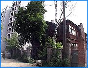 ></p><p class=c_tn>Котлован под новый корпус высотного жилого здания в Конспиративном переулке подошел вплотную к старым двухэтажным домам. С их сносом не согласны многие жители и руководство территориального совета самоуправления. Однако зеленая зона в самом центре Иванова может быть поглощена элитными зданиями московской строительной фирмы. </p><p class=c_tn>Стрела экскаватора, который не останавливается ни на минуту, уже почти не видна над котлованом. Тяжелые грузовики вывозят грунт. Кран навис не только над девятью этажами кирпичной коробки, но и над малой застройкой Конспиративного переулка. Котлован вплотную подошел к первому из домов, которые тоже считались элитными полвека назад - их строили для директоров и инженеров текстильных фабрик. Среди соседних трущоб дома с отоплением, газом, горячей водой, в зелени плодовых деревьев и огородов казались воплощением мечты о городе-саде. Они и сегодня крепки. </p><p class=c_tn>А система жизнеобеспечения здесь двойная по сравнению со стандартными домами. </p><p class=c_tn>Кроме обычной горячей воды - газовые колонки. Систему отопления заменили 5 лет назад, но всегда можно затопить печь. В ухоженные огороды можно выйти прямо с веранды. Под окнами поют соловьи, клубнику накрывают от птиц сетками. Дома могли бы стоять еще лет 100, а то и превратиться в особняки. Но столичная компания намерена снести их и выстроить небоскребы для небедных жильцов. Она предложила жителям другие квартиры, в обычных девятиэтажках. Те долго сопротивлялись. </p><p class=c_tn>Активно против выселения настроены две семьи. Ветеран Олег Насекин наотрез отказался вести переговоры с инвесторами. Он рассылает письма, пытаясь объяснить чиновникам, что такие дома в таком месте сносить нельзя. В ответ - молчание или отписки. «Обращаемся к областному прокурору. Прокурор рассылает в районные отделения. К нам приходит милиционер. - Вас били? - Нет. - Вам грозили? - Нет. - Так чего же вы жалуетесь?» - рассказывает ветеран. А повестки от районного прокурора, - говорит Олег Аркадьевич, - почему-то разносила та соседка, что была заинтересована в переезде: «И она разносила в избирательном порядке тем, кто качается, кто неуверен. Как вел разговор с ними районный прокурор, это нам неизвестно. Но после этого они все стали подписантами. А это дало право Грошеву приговорить наши дома к сносу». </p><p class=c_tn>В этих домах все дышит историей нескольких поколений. Олег Аркадьевич рисует картины и говорит: нельзя рубить корни. </p><p class=c_av>Василий Когаловский</p>
	
		<div class=
